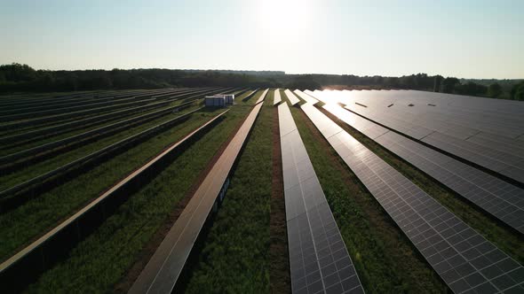 Aerial View of Solar Farm on the Green Field at Sunset Time Solar Panels in Row alt