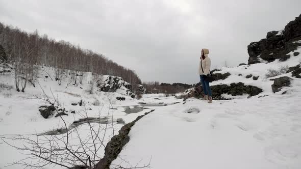Sports Girl in Warm Clothes and Trekking Shoes Walks in the Winter Forest