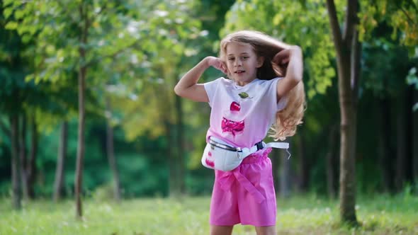 Little girl enjoying life. Happy little girl having fun, enjoying, spinning fast in a park alt