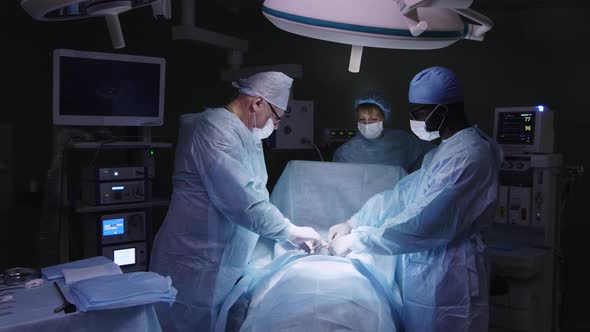 Diverse surgeons operating patient