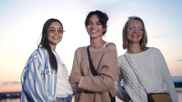 Three happy young casual women standing and smiling to camera. alt