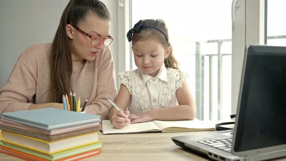 Mom Helps Little Elementary School Student Her Homework alt