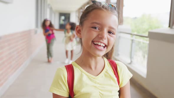 Video of happy caucasian girl standing on school corridor alt