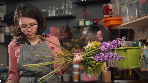 Woman Florist Is Making Flowers Bouquet During Working Day in Modern Workshop.
