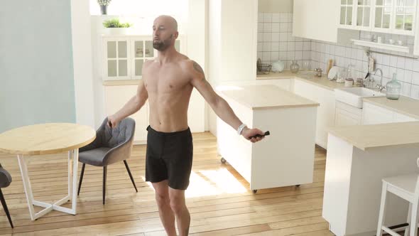 Muscular Athletic Man Is Jumping Rope Making Cardio Training at Home in Kitchen
