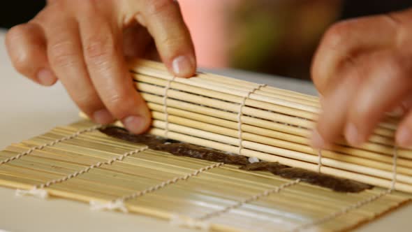 Hands Make Long Sushi Roll. alt