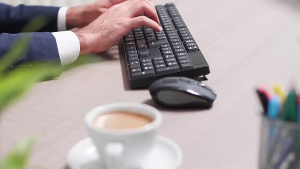 Businessman at His Desk Using a Computer Keyboard alt