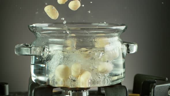 Super Slow Motion Shot of Fresh Gnocchi Falling Into Boiling Salted Water at 1000 Fps. alt