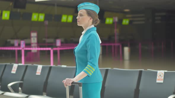 Cheerful Flight Attendant Greeting Colleague in Airport. Side View Portrait of Beautiful alt