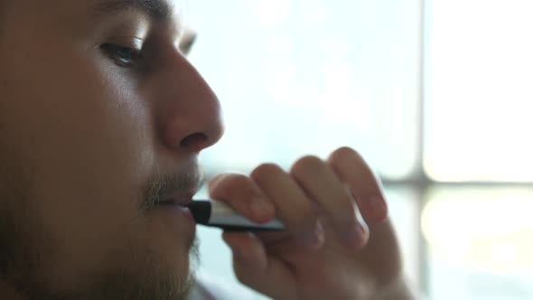 Closeup of Man Inhaling an Ecigarette Vaping Device