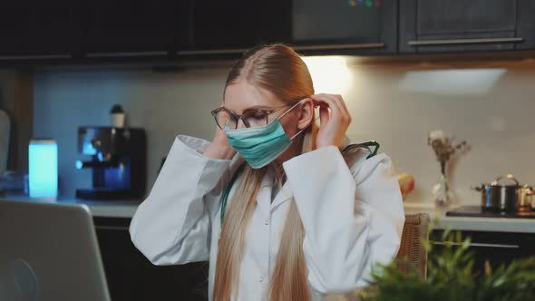 Female Doctor Showing How To Wear Medical Mask By Video Call on Computer alt