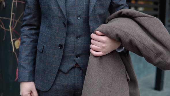 Close-up of Stylish Male Businessman in Brown Suit and Coat on Wooden Background alt