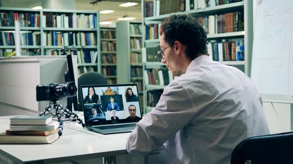 Male Professor Greeting Students During an Online Geometry Class alt