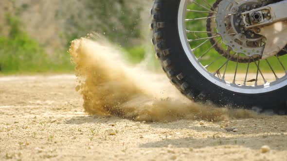 Close Up Wheel of Powerful Off-road Motorcycle Starting Movement. Motocross Bike Starts Move. Dry alt