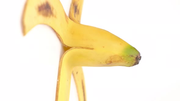 Banana peel rotation isolated on white background, Close up. Vertical Video Format