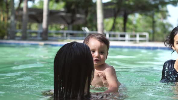 Mom and Baby are Having Fun in the Pool the Baby is in Waterproof Diapers
