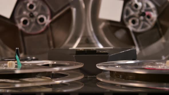 Two Reel to Reel tape recorders playing music together with four tapes alt