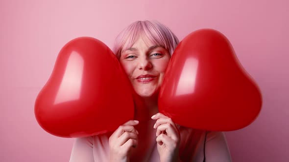 Happy Beautiful Woman in Good Mood Smiling Holding Red Shaped Heart Air Balloons Celebrates Birthday