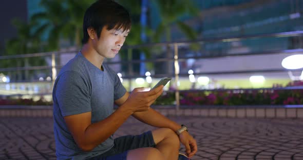 Young man use of cellphone at night alt