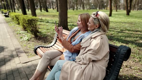 Women Sitting on Bench and Have Selfie