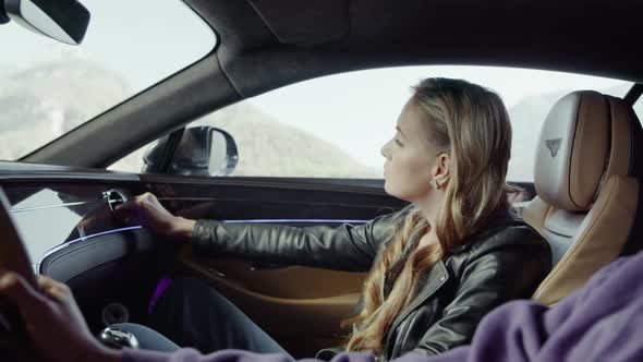 The girl, the passenger corrects the air duct grille.