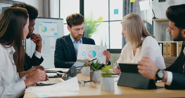 Businesspeople Working Together in Office Room and Discussing Reports with Chart alt