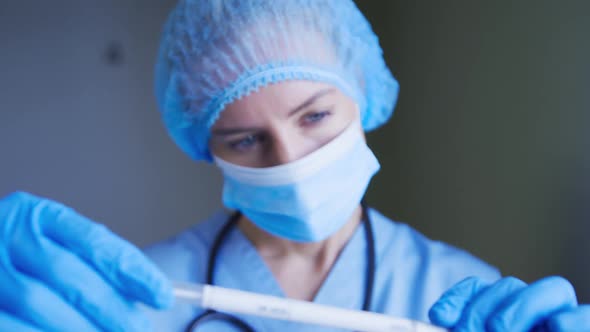 Female caucasian doctor wearing protective clothes reparing covid swab test for patient alt