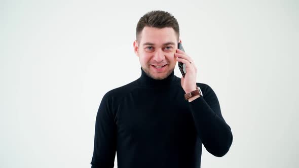 Portrait of a smiling man talking on the phone.  alt