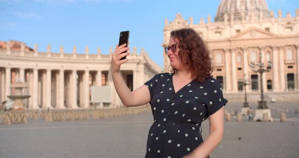 Young Caucasian female makes selfie in front of Vatican cathedral in Rome