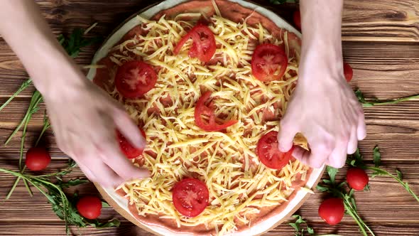 Raw Pizza with tomatoes, olives and ham, Italian style on old wooden table, top view alt
