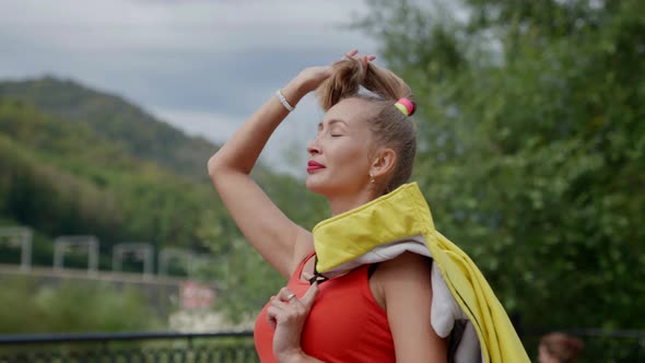 Portrait of a Blonde in Red Clothes and with a Yellow Jacket on Shoulder alt