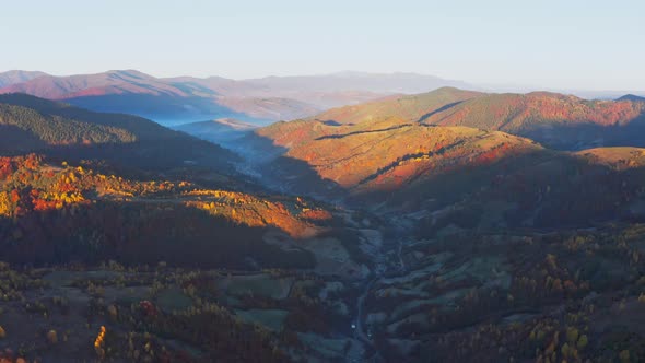 Shaded Mountain Valley with Houses and Forests at Sunset alt