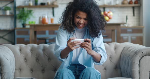Funny African American Woman Playing on Her Smartphone Exciting Mobile Application alt