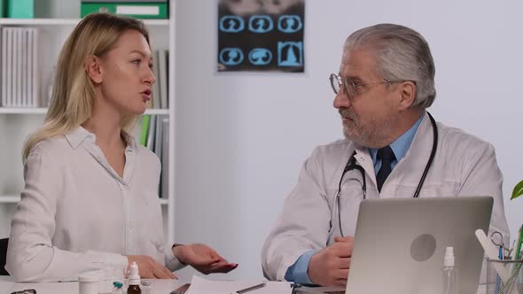 Woman Patient at Family Doctor Appointment Talks About Symptoms of Her Illness alt