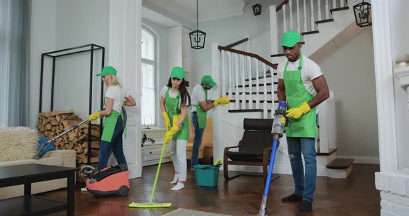 Professional Multiracial Team of Cleaners Cleaning Up Client's Beautiful Apartment alt