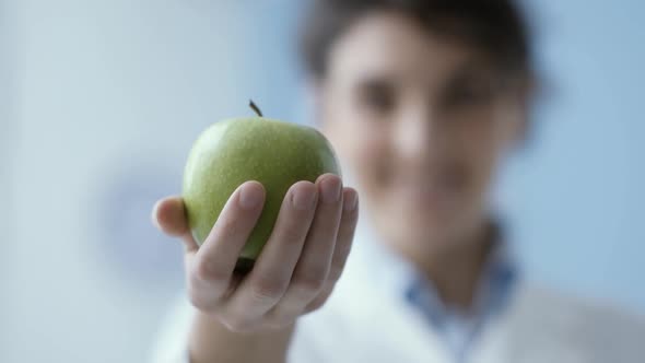 Professional nutritionist holding a fresh apple