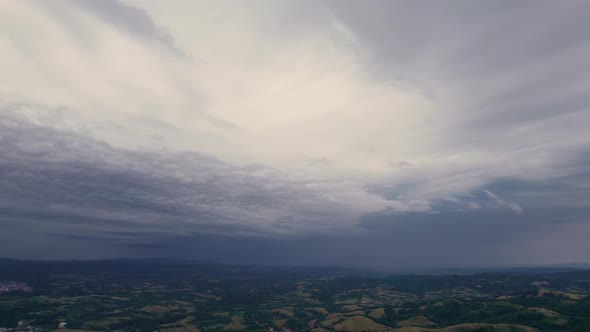 Aerial time lapse of approaching storm, over hills