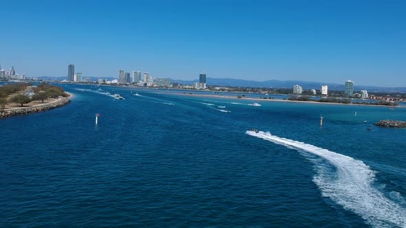 Aerial view of a busy day on popular waterway with a city skyline in the distance alt
