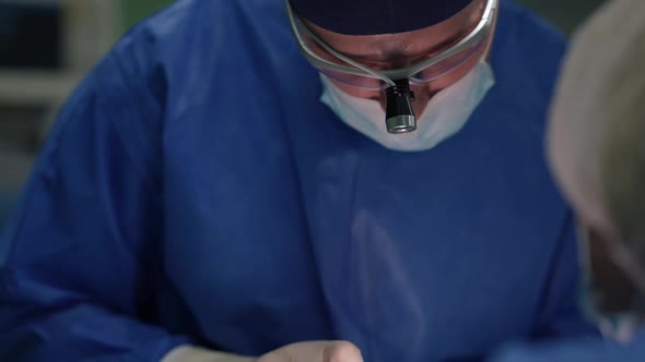 Portrait of Caucasian Expert Surgeon Stitching Dissection with Cautery Machine Doing Blepharoplasty alt