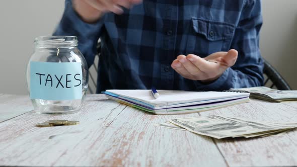 Man analyzing monthly budget, saving money coins for unpaid taxes alt