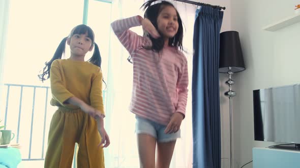 asian female children siblings having fun together in the living room alt