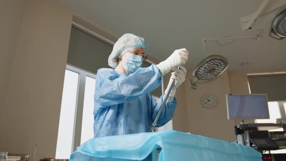 Portrait of a Female Healthcare Worker in a Protective Mask Standing at a Table alt