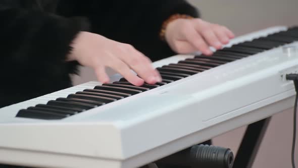 the boy's hands play the piano keyboard on the street. hands on piano keys close-up.