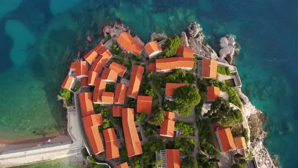 Amazing sunset aerial top drone view of Sveti Stefan island with historical town