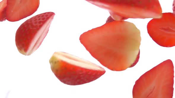Closeup of the Halves of Delicious Strawberries Falling Diagonally alt