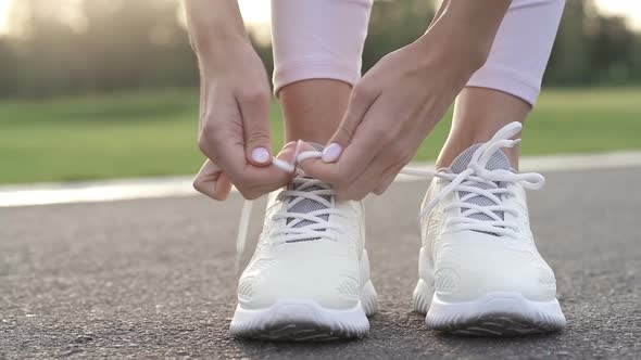 Woman tie shoelaces. 