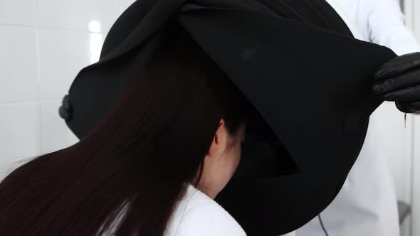 Body Massage  Young Woman Puts Her Head Under the Black Cloth alt