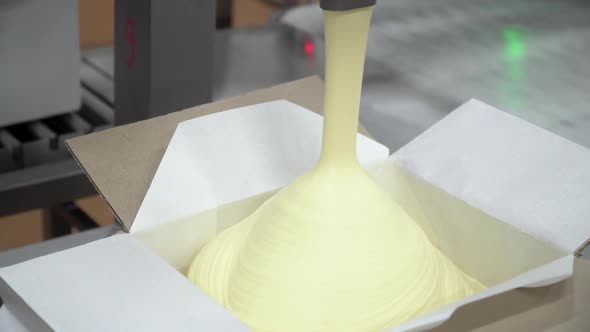 The Process of Packing Oil Into Boxes. Closeup View of Packing Machine alt