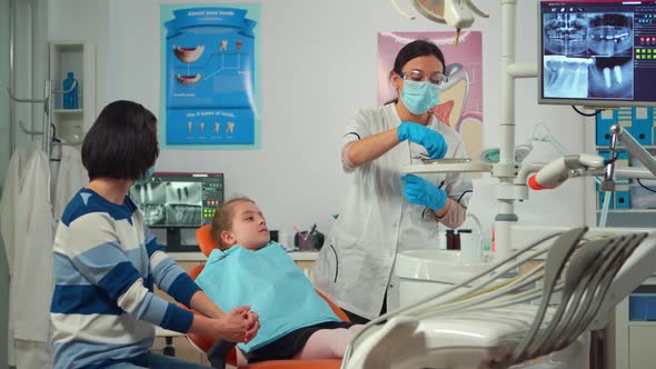 Pediatric Dentist with Mask Checking Dental Health of a Little Girl alt