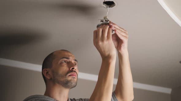 A Young Man is Repairing a Ceiling Soffit